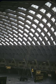 the inside of an airport with many windows and ladders on it's sides