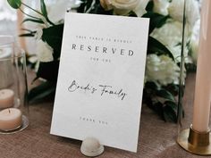 a table with candles, flowers and a sign that says reserved for the bride's family