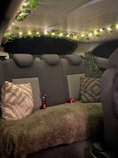 the interior of a car with christmas lights in the ceiling and decorative pillows on the floor