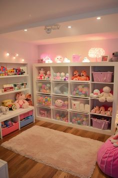 a room filled with lots of toys and stuffed animals on the shelves next to a bed