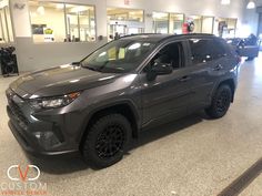 a gray suv is parked in a showroom