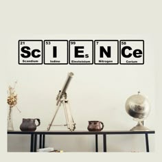 the science wall decal is shown above a table with various items on it, including a telescope and an earth globe