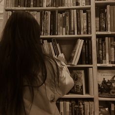 a woman standing in front of a book shelf filled with books