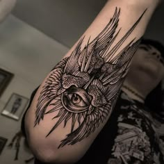 a man's arm with an all seeing eye and bird tattoo on his arm