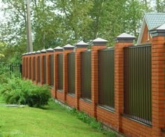 a row of red brick fences next to green grass