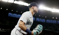 a baseball player holding a catchers mitt in front of a stadium filled with people