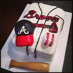 a birthday cake for a baseball player with a bat and hat on it's side