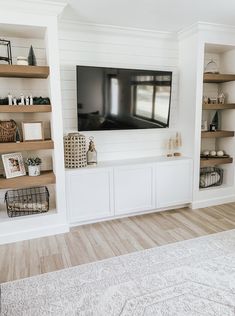 a flat screen tv mounted to the side of a white wall in a living room