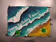 a birthday cake that is decorated with the ocean and turtle's name on it