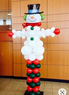 an inflatable snowman standing on top of a wooden floor next to a wall