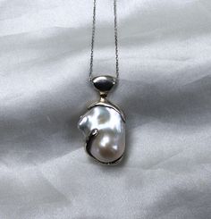 Elevate your jewelry collection with our exquisite Sterling Silver Pearl Armor Pendant Necklace. This stunning piece features a beautifully crafted pendant that combines the timeless elegance of a lustrous baroque pearl with the strength of sterling silver. The pendant is designed  symbolizing protection and resilience, making it a perfect statement piece for any occasion. The natural sheen of the pearl adds a touch of sophistication, beautifully contrasting with the sleek silver armor. Perfect for layering or wearing solo, this necklace is both versatile and eye-catching. Whether you're dressing up for a special event or adding a unique flair to your everyday look, the Sterling Silver Pearl Armor Pendant Necklace is sure to turn heads and spark conversations. Details: Material: Sterling S Pearl Armor, Silver Armor, Necklace Charm, The Pearl, Silver Pearls, Baroque Pearls, Special Event, Pendant Necklaces, Charm Necklace