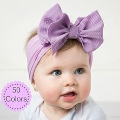 a baby girl with a purple bow on her head