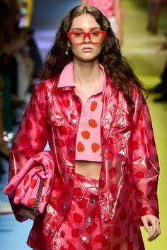 a model wearing red glasses and a pink top on the runway at louis vuittot