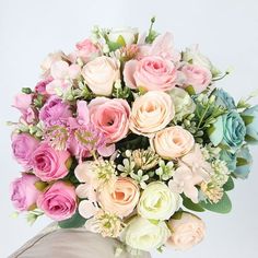 a bunch of flowers that are sitting in a vase on a table with white background