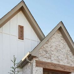 a brick house with an open window and shutters