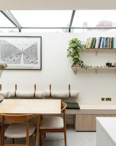 a room with a table, bookshelf and shelves filled with books on the wall