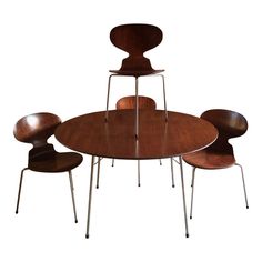 an oval table with four chairs and one chair on the bottom is made out of wood