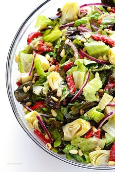 a salad in a glass bowl on a white table