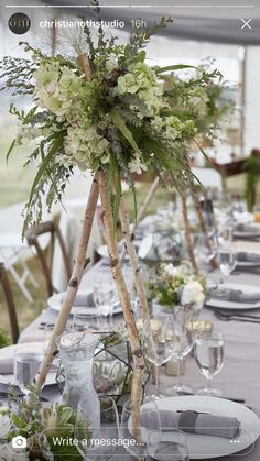 the table is set with white flowers and greenery for an elegant wedding or special event