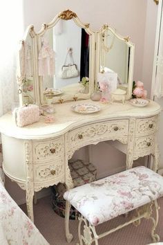 a white dressing table with mirror and stool