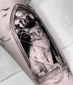 a black and white photo of a cat in a cage on the arm with bats