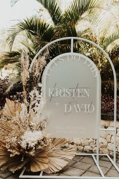 a sign that says kristen and david on it in front of some palm trees