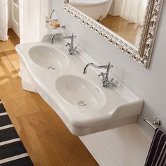 a bathroom with two sinks and a mirror on the wall above it in front of a bathtub