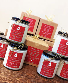 six candles with labels on them are sitting on a wooden table next to some boxes