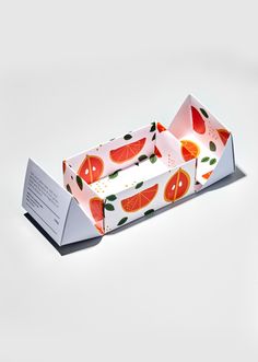 an origami box with slices of watermelon and leaves on the inside