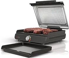 an electric grill with two hamburger patties on it