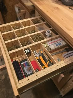 an open drawer in a workbench with tools and other items on the table