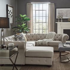 a living room filled with furniture and a fire place in front of a large window