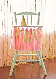 a pink and gold baby's 1st birthday party chair with the word love on it