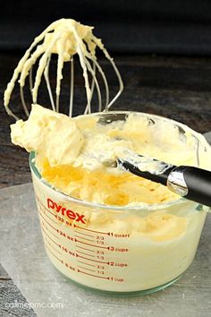 a mixing bowl filled with batter and a whisk on top of the mixer