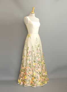 a white dress with yellow and pink flowers on it