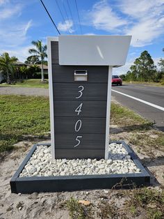 there is a sign that has been placed in the sand by the side of the road