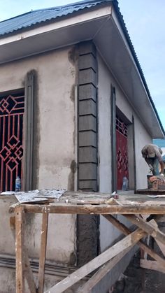 a small building with a red door and window