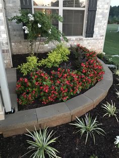 a flower bed in front of a house