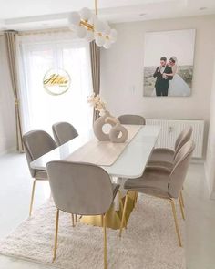 a dining room table with chairs and pictures on the wall