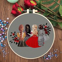 three women in dresses are sitting on a table next to flowers and bead spools