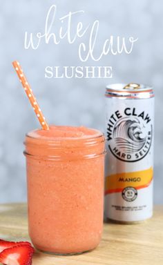 a strawberry smoothie in a mason jar next to a can of white claw slushie