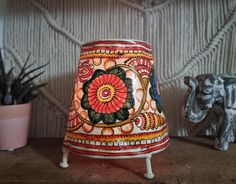 an elephant figurine is sitting next to a decorative vase and potted plant