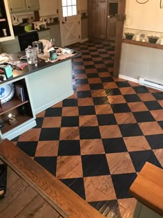 the kitchen floor is being remodeled and painted black and white checkerboard tiles are scattered across the room