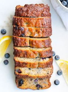 slices of blueberry banana bread stacked on top of each other with lemons around them