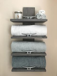 three shelves holding towels and other items in a bathroom