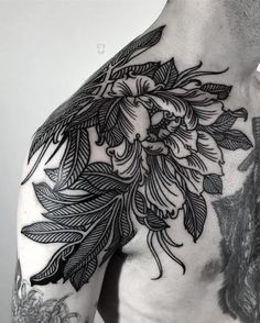 the back of a man's shoulder with flowers and leaves on it