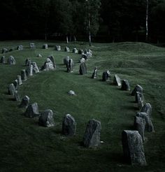 a group of large rocks sitting on top of a lush green field