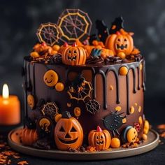 a halloween cake with chocolate icing and pumpkins on top, surrounded by candles