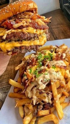 a sandwich and french fries are sitting on a white plate next to a wooden cutting board