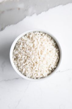 white rice in a small bowl on a marble surface